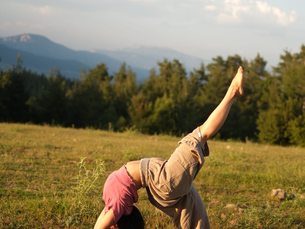 Yoga im Freien auf einer Wiese an einem Sommertag.